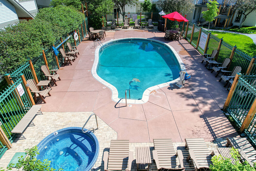 a swimming pool with chairs and a hot tub