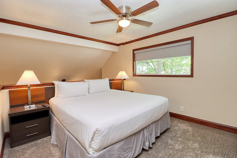 a bedroom with a ceiling fan and a bed