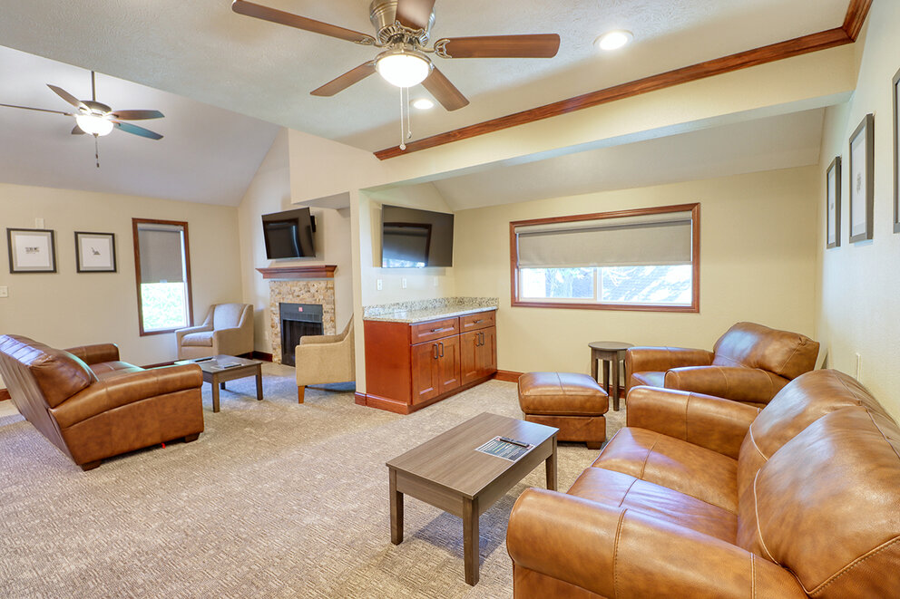 a living room with leather couches and a fireplace