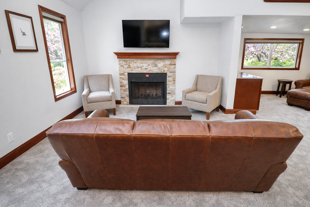 a living room with a fireplace and leather couches