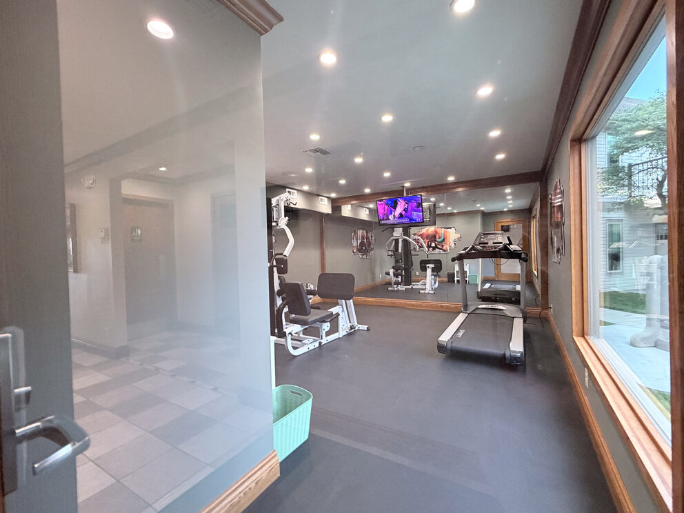 a room with exercise equipment and a television
